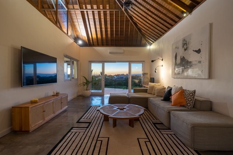 Open-plan living room at Villa Amerta A with high timber ceiling, large smart TV and sliding doors to the garden